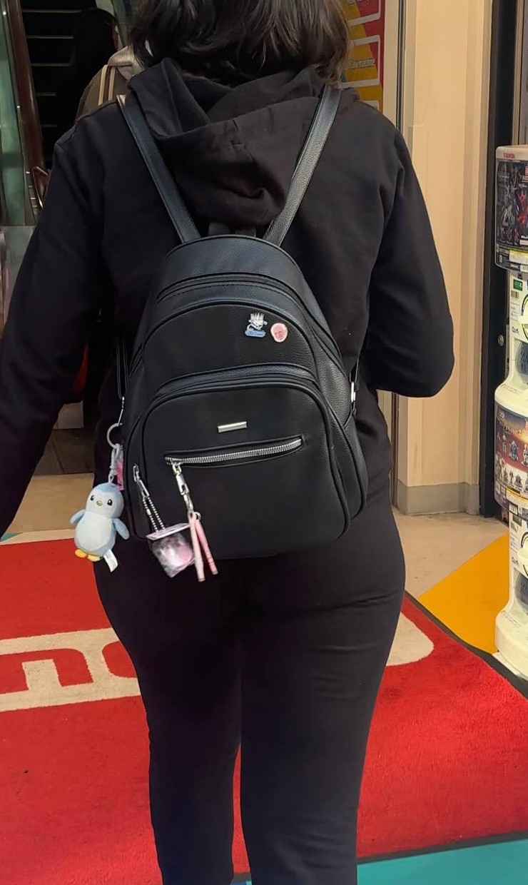 Pudgy Penguins plushie hanging from Vana's black backpack
